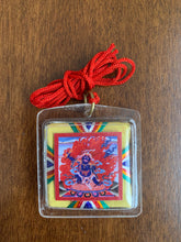 Load image into Gallery viewer, A clear square shaped amulet of the deity, Nam Jon. A red thread is attached to the amulet by a metal ringlet so it could be worn. The image of Nam Jon inside the amulet and decorated with thread details on the back. The amulet has smooth edges.