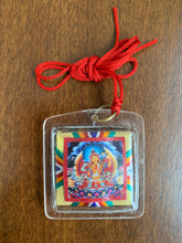 Load image into Gallery viewer, A square shaped amulet of the Loving Mother, Sherab Jamma. A red thread is attached to the amulet by a metal ringlet so it could be worn. The image of Sherab Jamma inside the amulet is colorful and decorated with thread details on the back. The amulet has smooth edges.